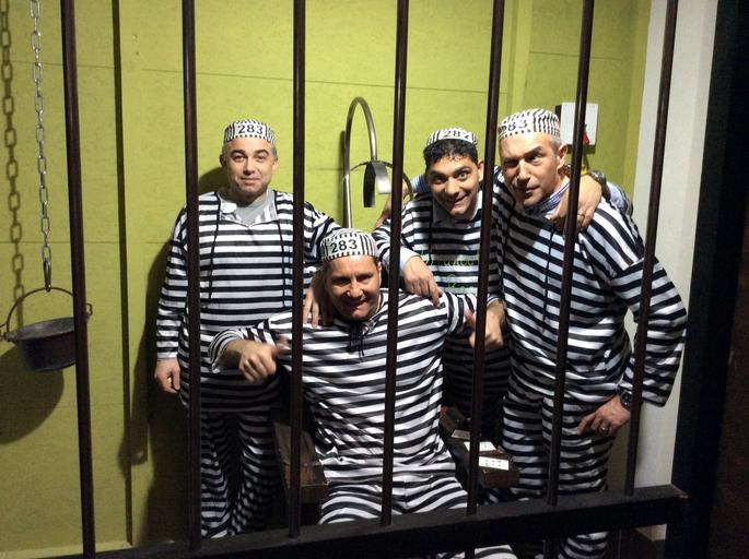 tým lidí, oblečených jako vězni, hrající únikovku